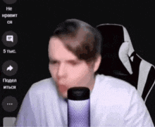 a man in a white shirt is talking into a microphone