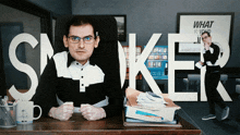 a man sits at a desk with the word smoker written on it