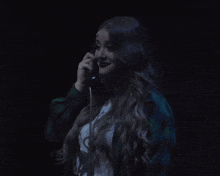 a woman in a plaid jacket is talking on a telephone