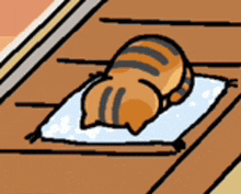 a cartoon cat is sleeping on a blanket on a wooden floor