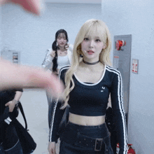 a woman wearing a black adidas crop top