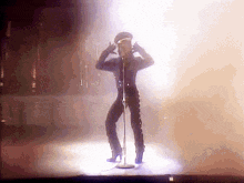 a man is singing into a microphone on a stage in front of a crowd .