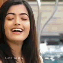 a close up of a woman 's face with her eyes closed and a smile on her face .