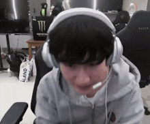a person wearing headphones with a microphone and a monster energy logo in the background