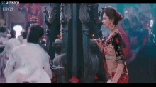 a woman in a crop top is standing next to a man in a white shirt and the words eros are on the bottom of the screen