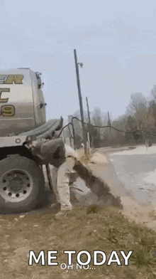 a man is standing next to a truck that is pumping water into a drain .