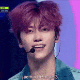 a young man with pink hair is wearing a microphone and says jaemin de more : 3