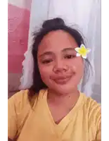 a woman wearing a yellow shirt with a flower in her hair