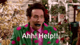 a man in a green and pink polka dot suit is saying ahh help