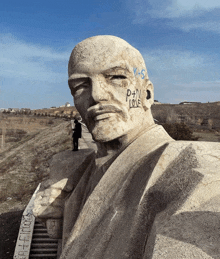 a statue of a man with graffiti on his face including the words p + n love