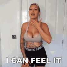 a woman wearing gymshark shorts and a sports bra says " i can feel it "