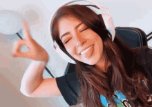 a woman wearing headphones is sticking her tongue out and making a peace sign