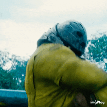 a close up of a person wearing a helmet and a yellow jacket with imgplay written below it