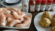 a bottle of cocktail sauce sits on a table next to a pile of shrimp