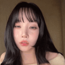 a close up of a girl with long black hair and bangs .