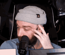 a man wearing a gray beanie and a shure microphone