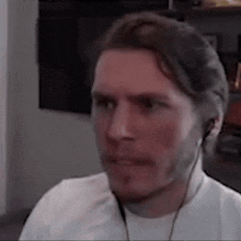 a man wearing headphones is making a funny face while looking at the camera .