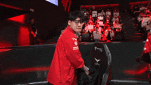 a man in a red jacket stands in front of a screen that says fantastic