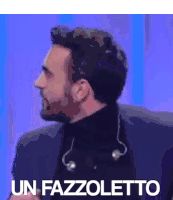 a man with a beard is wearing a black turtleneck and headphones and says un fazzoletto