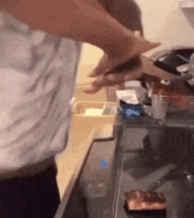 a man is cutting a piece of meat on a stove top .