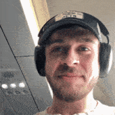 a man wearing a jets hat and headphones