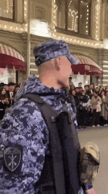 a man in a military uniform has a patch on his back that says ' x ' on it