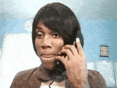 a woman is making a funny face while talking on a phone .