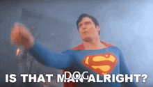 a man in a superman costume is holding his fist up in the air and says `` is that man alright ? ''