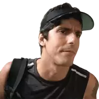 a man wearing a black tank top and a visor