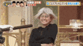 a woman wearing a white wig is smiling while holding a microphone