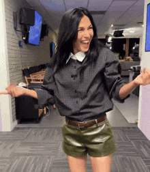 a woman in shorts and a plaid shirt is dancing