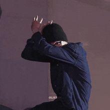 a man wearing a denim jacket and a black beanie is dancing
