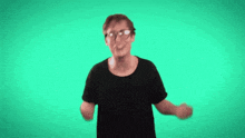 a man with glasses is raising his arms in the air