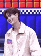 a young man with a name tag that says ' มา รัก ' on it smiles