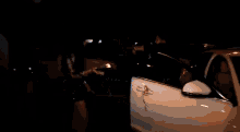 a group of people are standing in a parking lot including a man in a suit