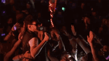 a man singing into a microphone in front of a crowd at a concert