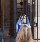 a woman in a nun costume is standing in front of a gate