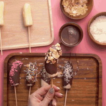 a person is holding a chocolate covered banana with sprinkles on it