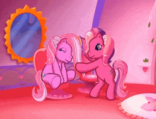 two pink ponies are standing next to each other