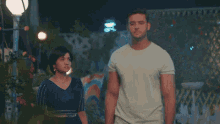 a man and a woman are standing next to each other and holding hands
