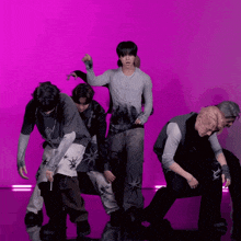 a group of men are dancing in front of a pink background