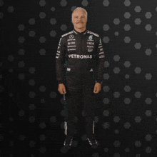 a man with a mustache is wearing a petronas racing suit