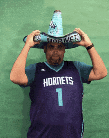 a man wearing a hornets jersey and a sombrero on his head