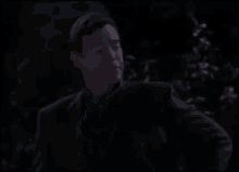 a group of people are standing in a dark room .