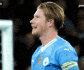 a soccer player in a blue jersey with the word peace on the bottom right