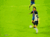 a blurry picture of a soccer game with a few players and a goalie in the background