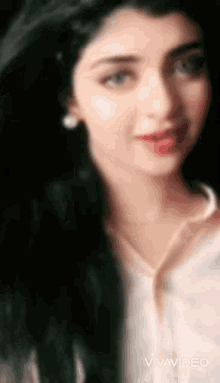 a close up of a woman 's face with a blurred background .