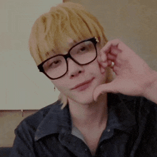 a person wearing glasses making a heart shape with their hands