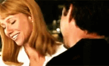 a man and a woman are smiling at each other .