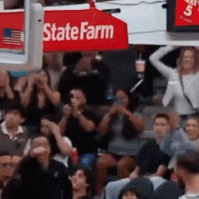 a crowd of people are sitting in a stadium watching a basketball game .